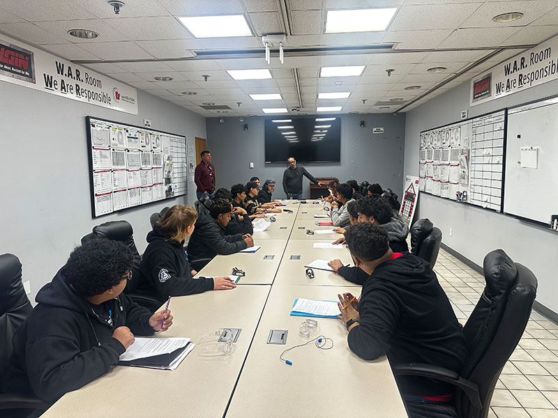 Students around table at Elgin Sweeper for 2026 Manufacturing Tour